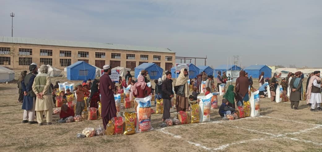 طالبان در حال پخش پول و مواد غذایی بین مهاجران افغان/عکس