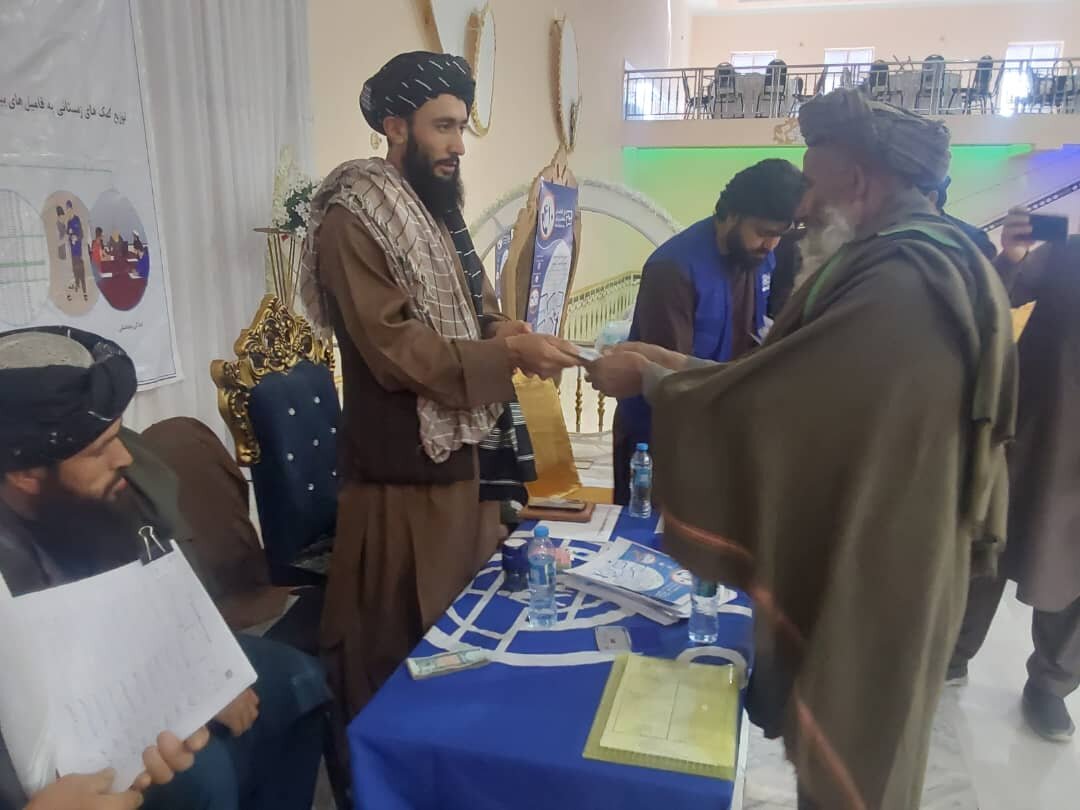 طالبان در حال پخش پول و مواد غذایی بین مهاجران افغان/عکس