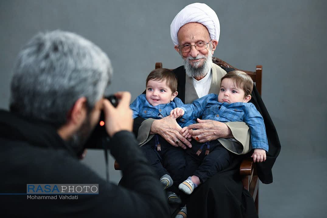 عکسی متفاوت از مصباح یزدی و دو کودک در آغوش او