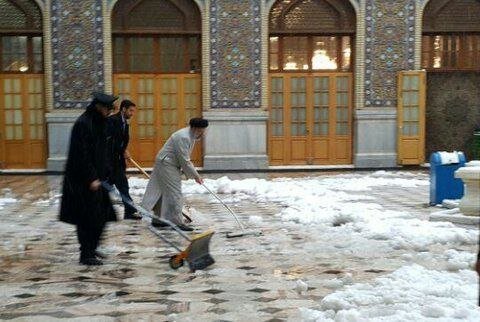 عکس | تصویری خاص از برفروبی صحن حرم امام رضا(ع) توسط شهید ابراهیم رئیسی