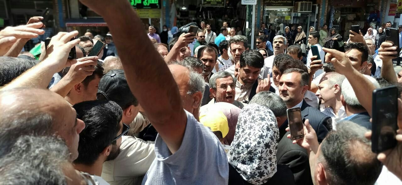 عکس های حاشیه ساز احمدی نژاد در شلوغی بازار تهران /سلفی با دختران و در آغوش گرفتن یک مردم