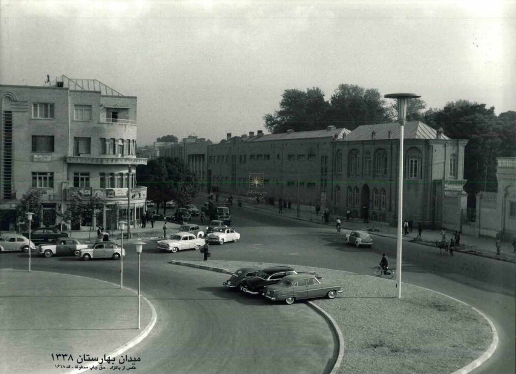 تهران قدیم| بدون ترافیک با تردد خودروهای کلاسیک؛ میدان بهارستان ۶۵ سال قبل/ عکس