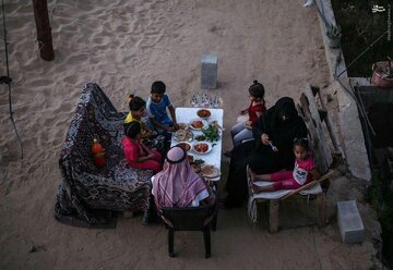 عکس | افطار خانواده فلسطینی در ویرانههای منزل در محله شیخ عجلین در غزه عکس | افطار خانواده فلسطینی در ویرانههای منزل در محله شیخ عجلین در غزه