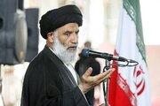 عکس | حضور امام جمعه اهواز با لباس نظامی و اسلحه در راهپیمایی