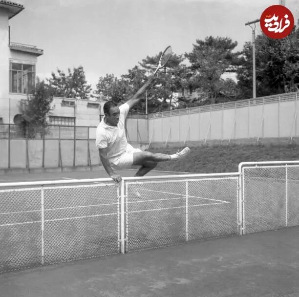 عکس/ «آنتونی کوئین ۴۵ سااله» در حال پریدن از روی نرده‌ زمین تنیس در ونیز؛ سال ۱۳۳۸