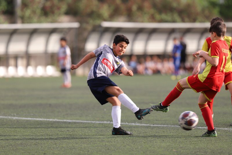 تصویر هیجان انگیز از فوتبال دو فوتبالیست نوجوان در زمین چمن