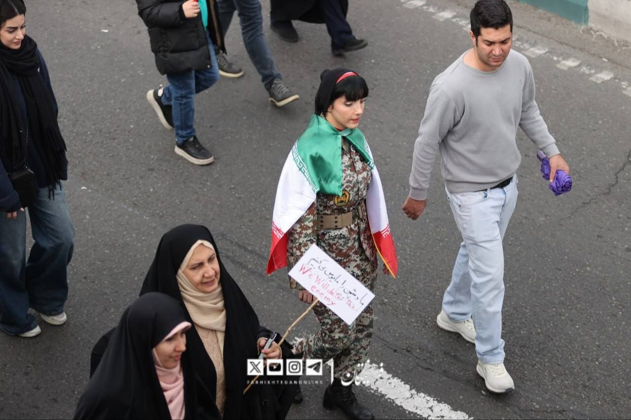 این خانم با لباس ارتشی در راهپیمایی 22 بهمن سوژه عکاس‌ها شد + تصویر