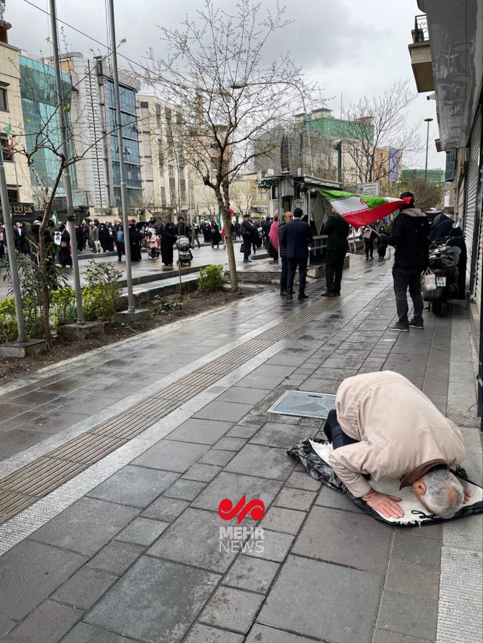 عکس | نماز خواندن یک مرد تهرانی در حاشیه راهپیمایی روز قدس بعد از حمله جنگنده‌های آمریکایی - اسرائیلی