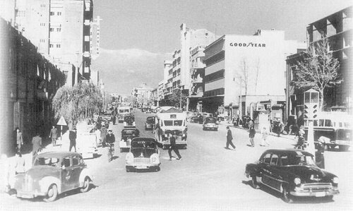 عکس|  راننده تهرانی در کنار ماشینش در یکی از خیابان‌های تهران؛ ۸۸ سال پیش