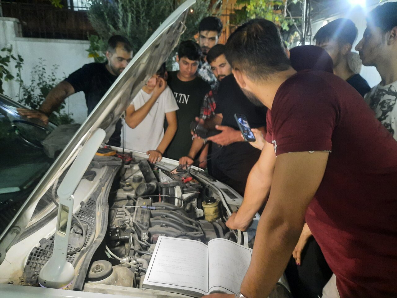 تصویری از یادگیری برق خودرو رو خودروی واقعی در آموزشگاه برق خودرو