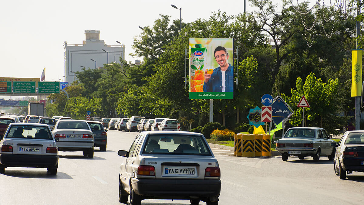 استرابورد عمودی کنار خیابانی درختی در مشهد، همتراز با خط دید رانندگان